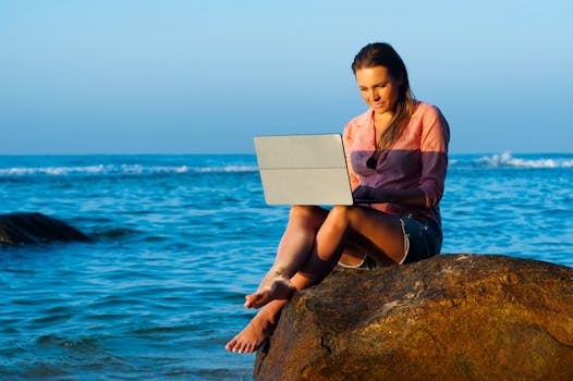 digital nomad working on a laptop at a beach