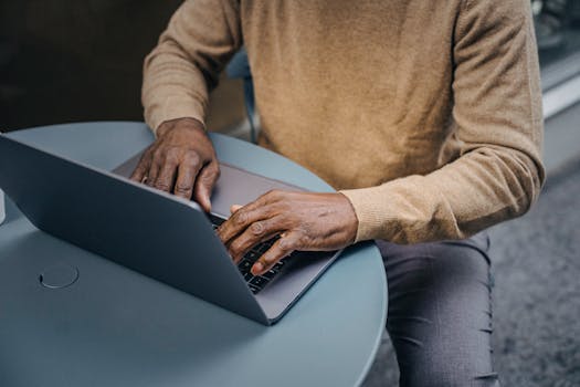 A digital nomad managing finances on a laptop at a cafe